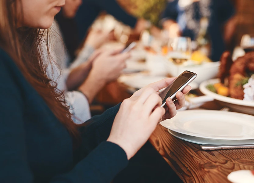 a woman using a cell phone at a table