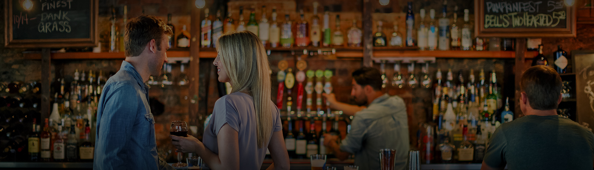 a woman standing behind a bar with a man behind her
