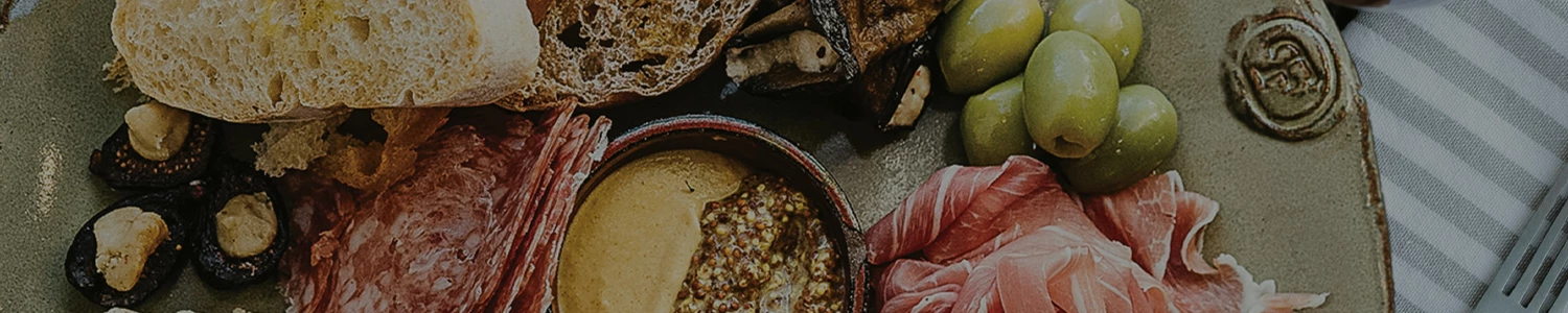 a bowl of food next to a plate of meat