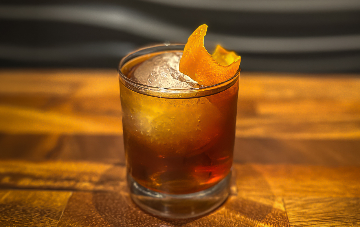 a glass with a drink and orange peel