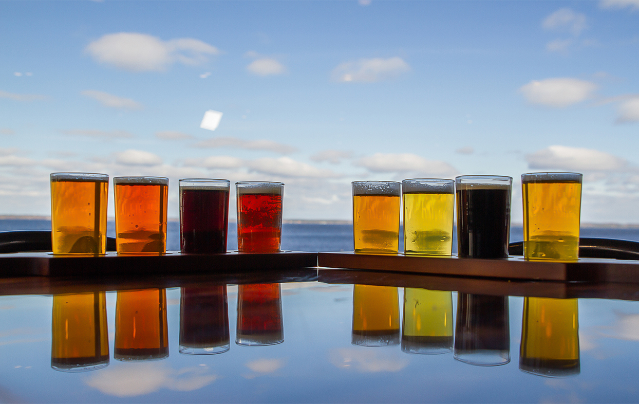 a row of glasses of beer on a table