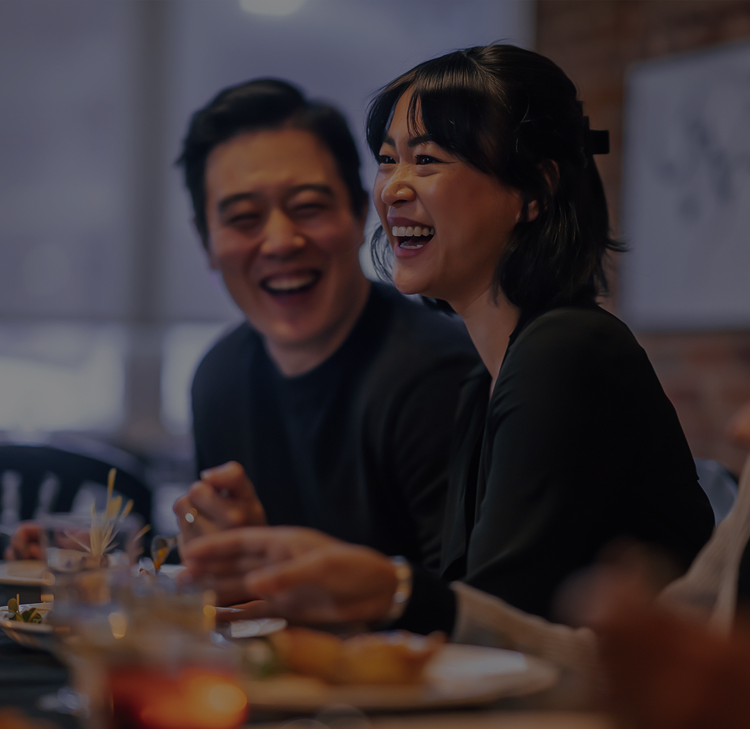 a man and woman laughing at a table