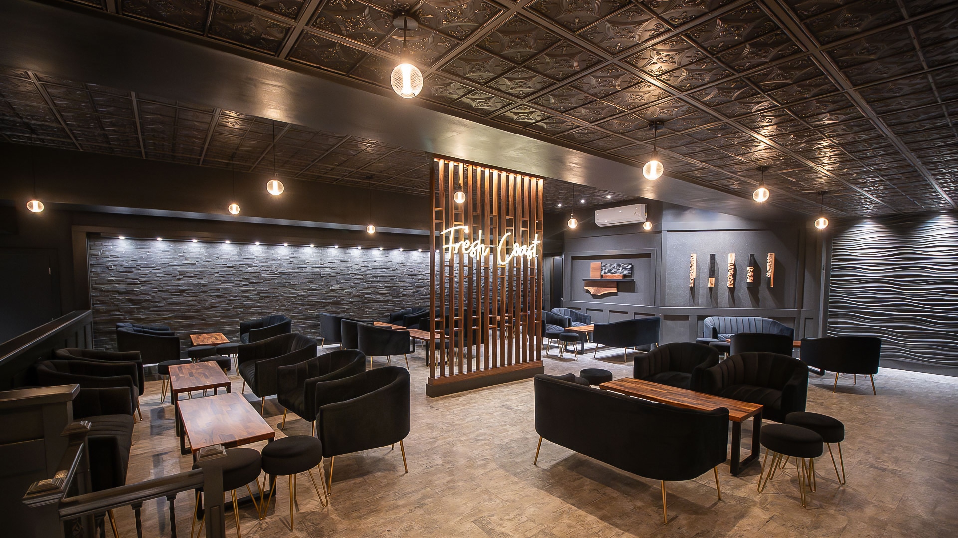 a room with black furniture and a wood paneled wall
