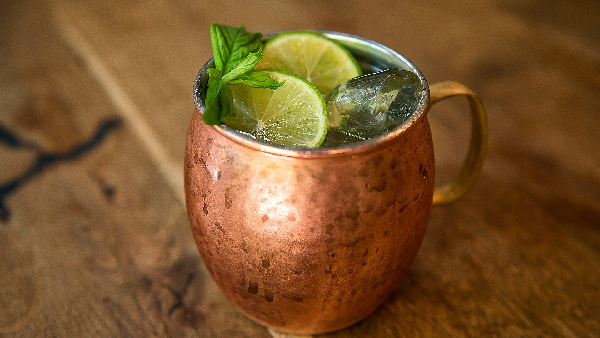 a copper mug with a drink and lime slices
