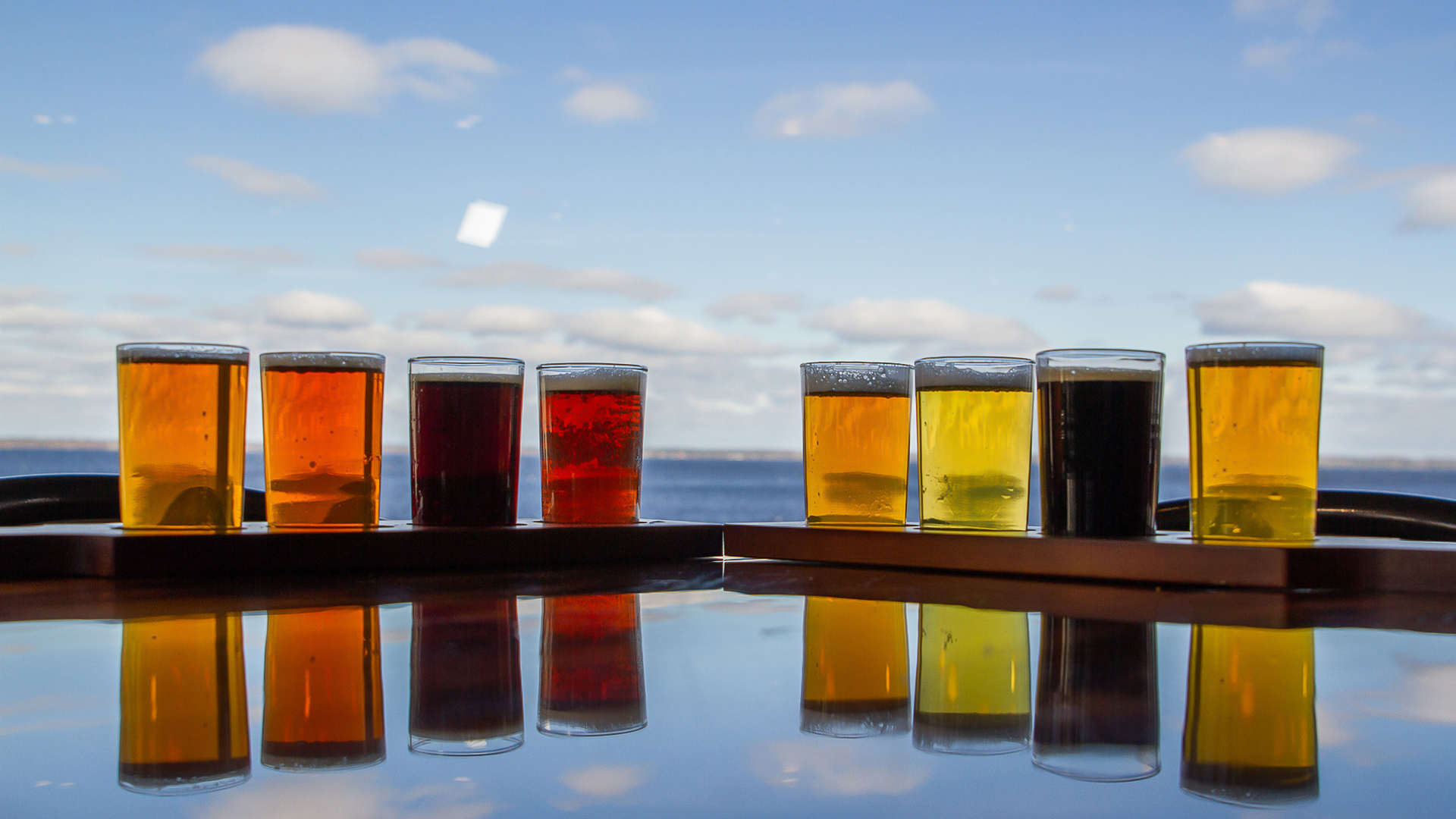 a row of glasses of beer on a table