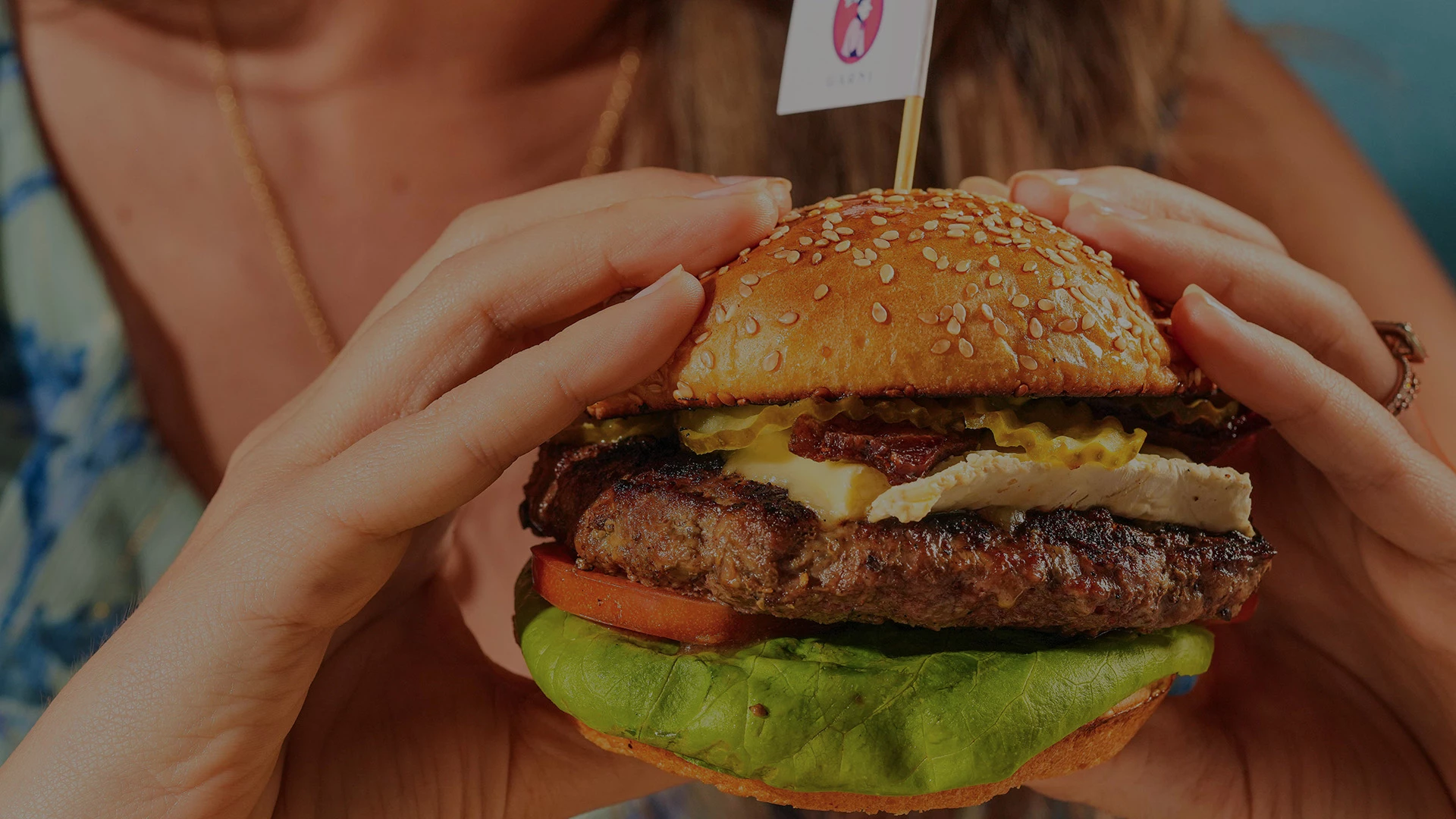 a person holding a burger