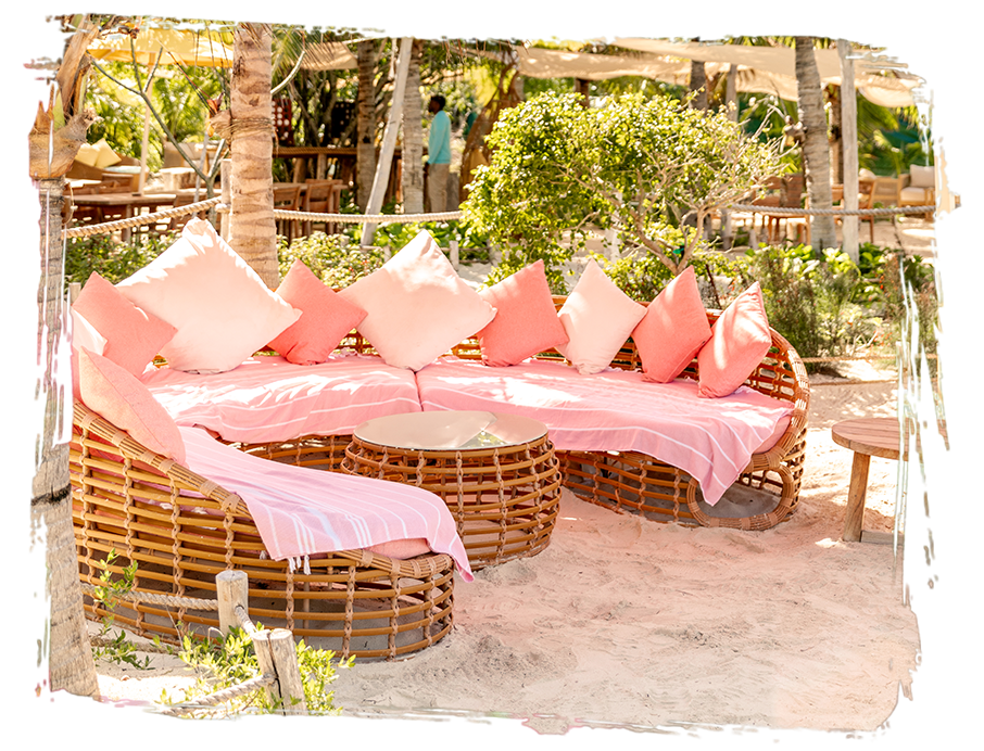 a group of wicker chairs with pink pillows
