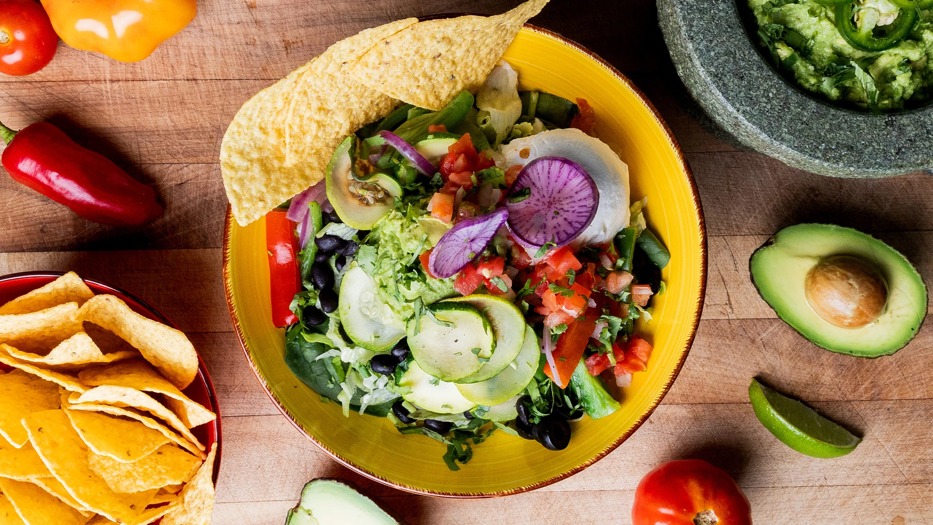 a bowl of salad with tortilla chips and tomatoes