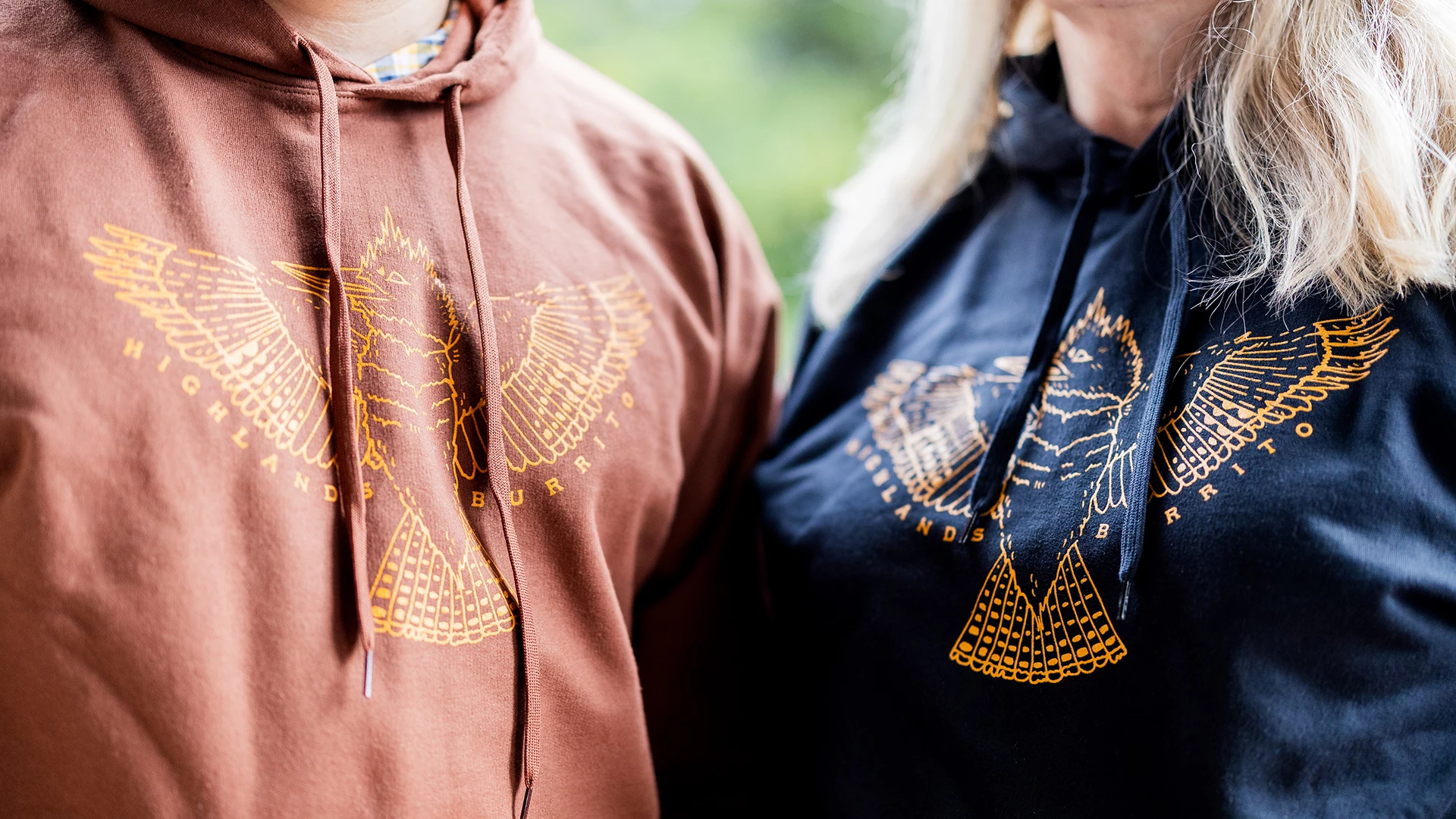 a man and woman wearing hoodies