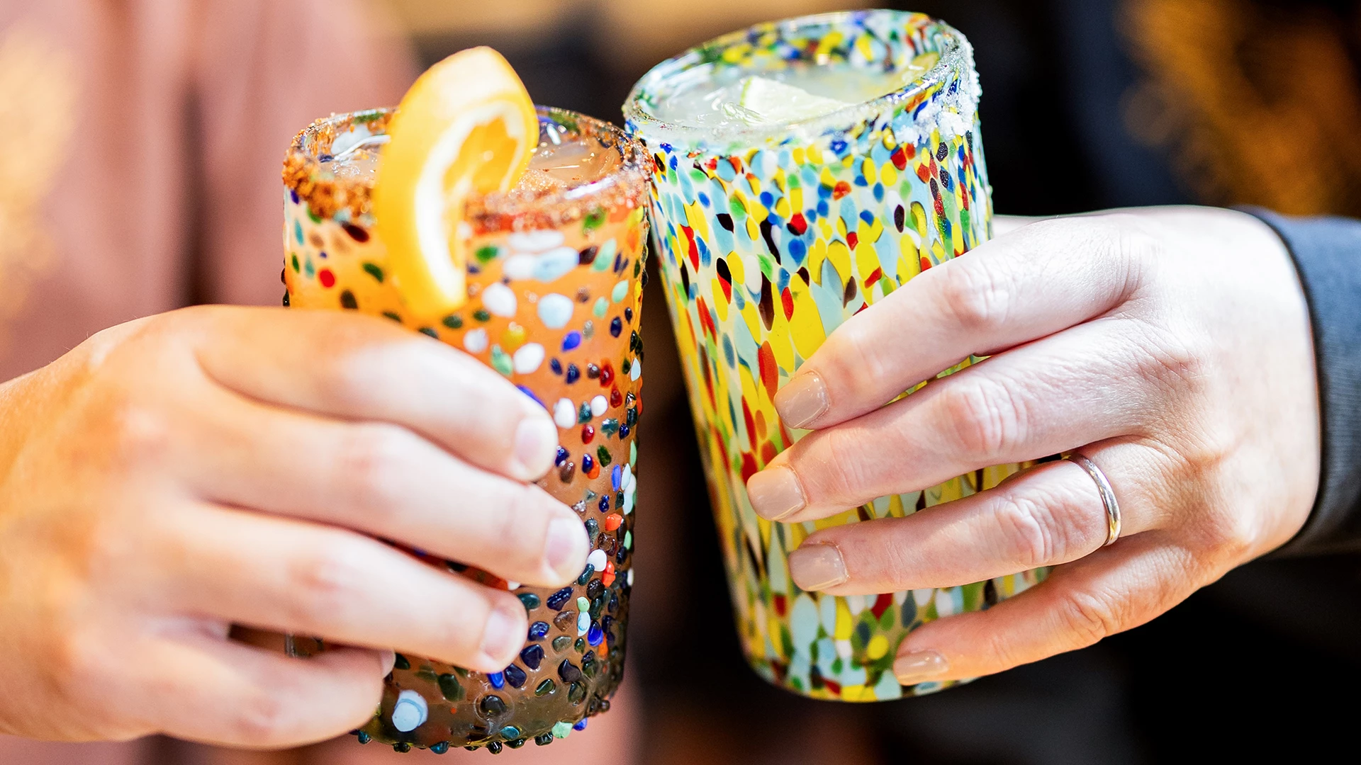 a pair of hands holding up colorful glasses