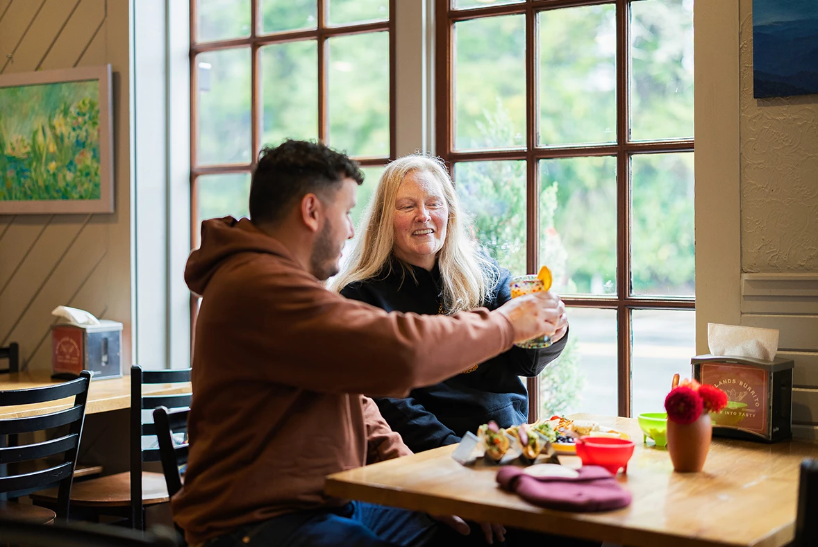a man and woman sitting at a table with food