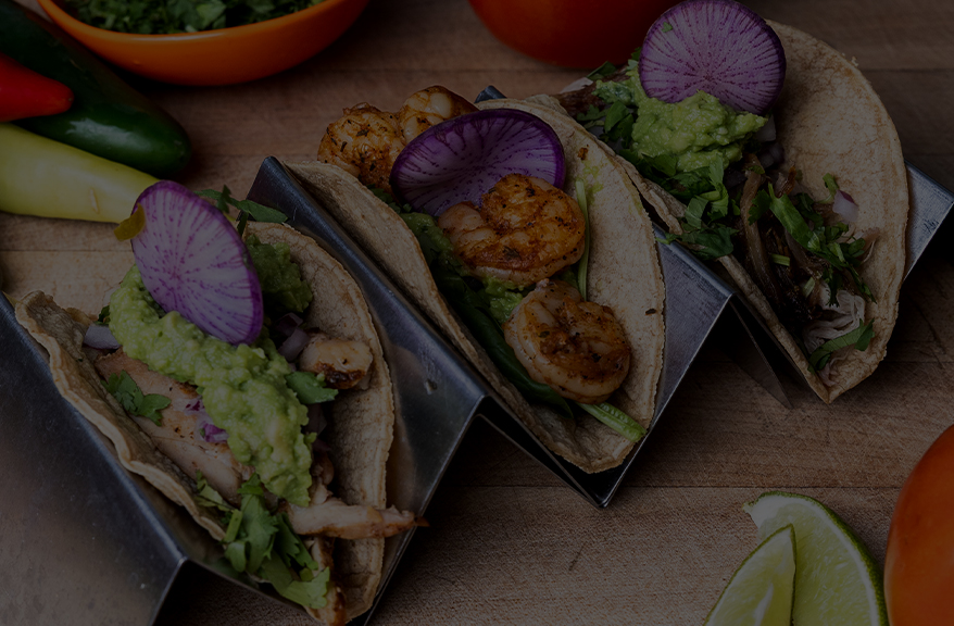 a group of tacos with shrimp and vegetables