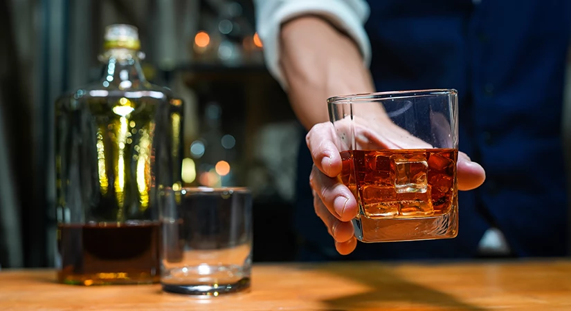 a hand holding a glass of alcohol