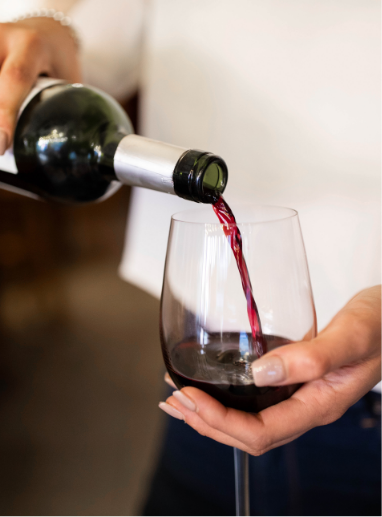 a person pouring wine into a glass
