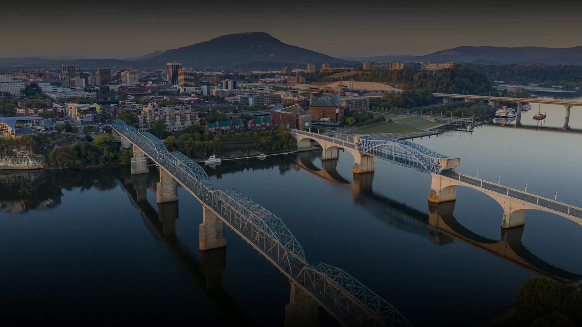 a bridge over water with a city in the background