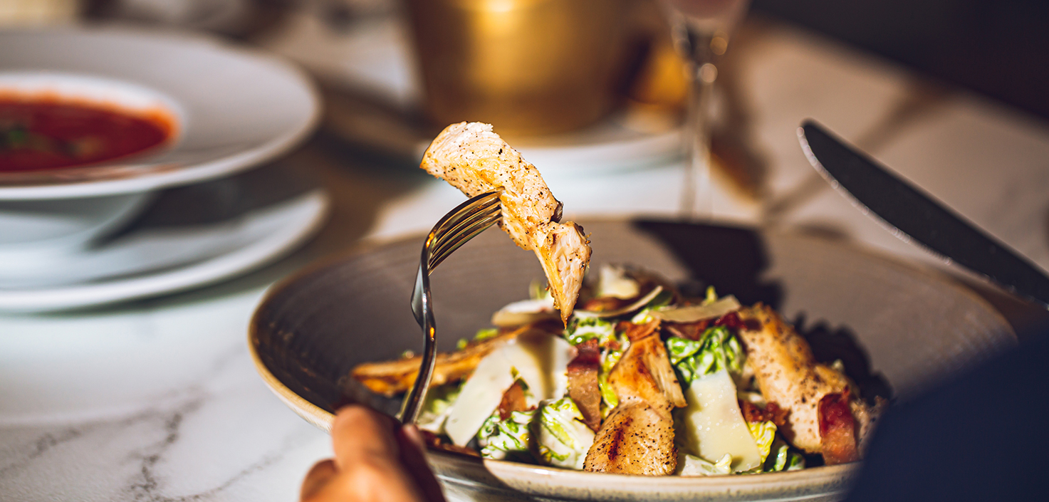 a person holding a fork over a salad
