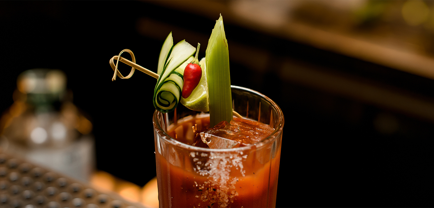 a glass with a drink and a vegetable garnish