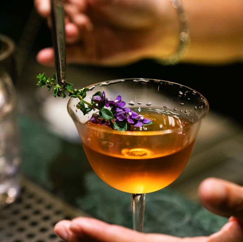 a person holding a drink with a flower on it