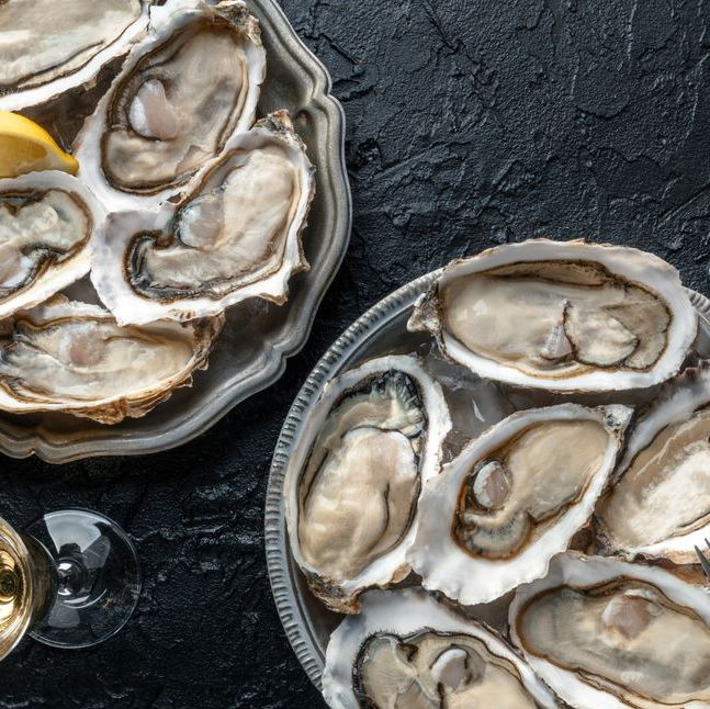 oyster oysters on a plate next to a glass of wine