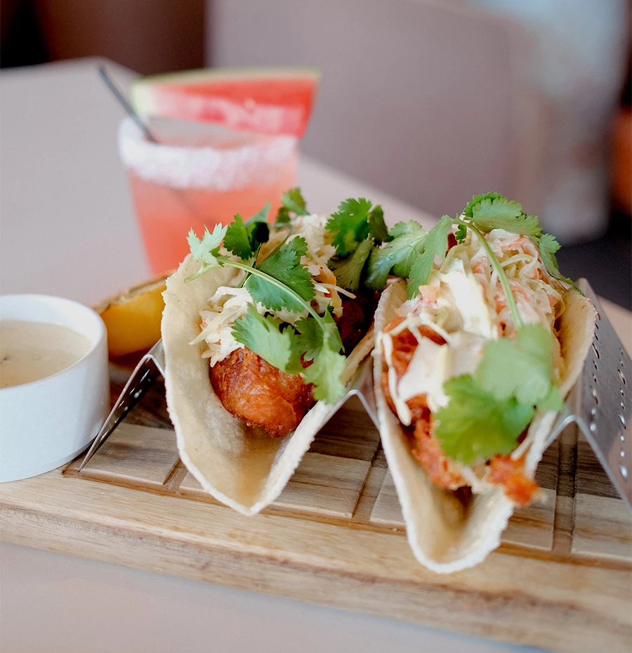 two tacos on a wooden board