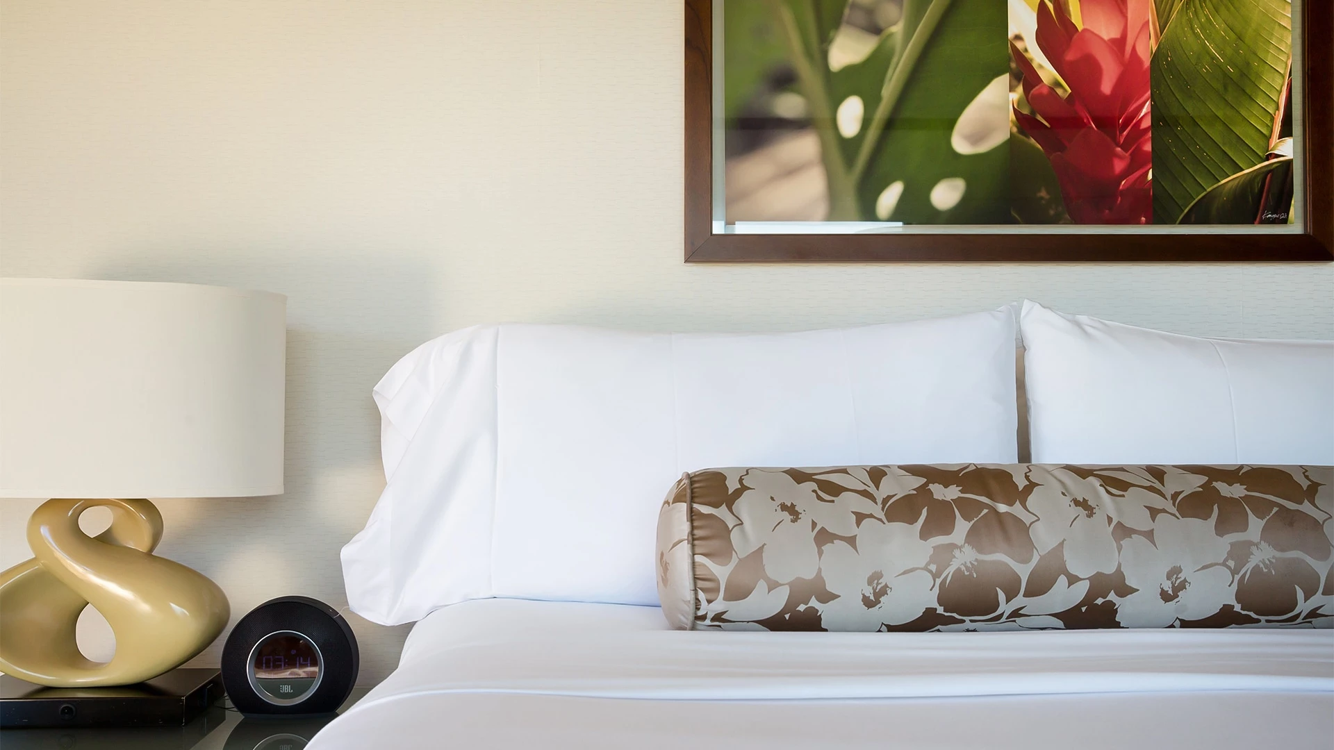 a bed with a white sheet and a brown pillow