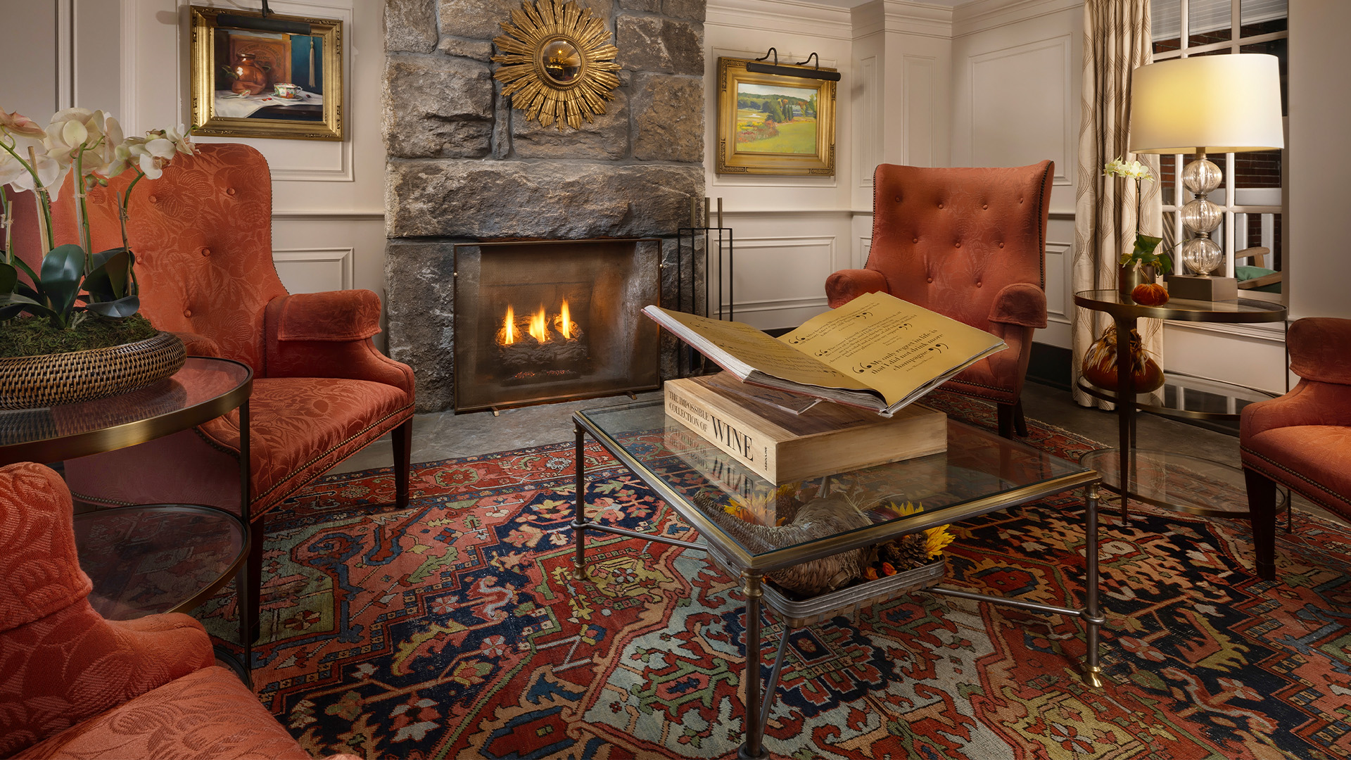 a room with a fireplace and a book on a glass coffee table