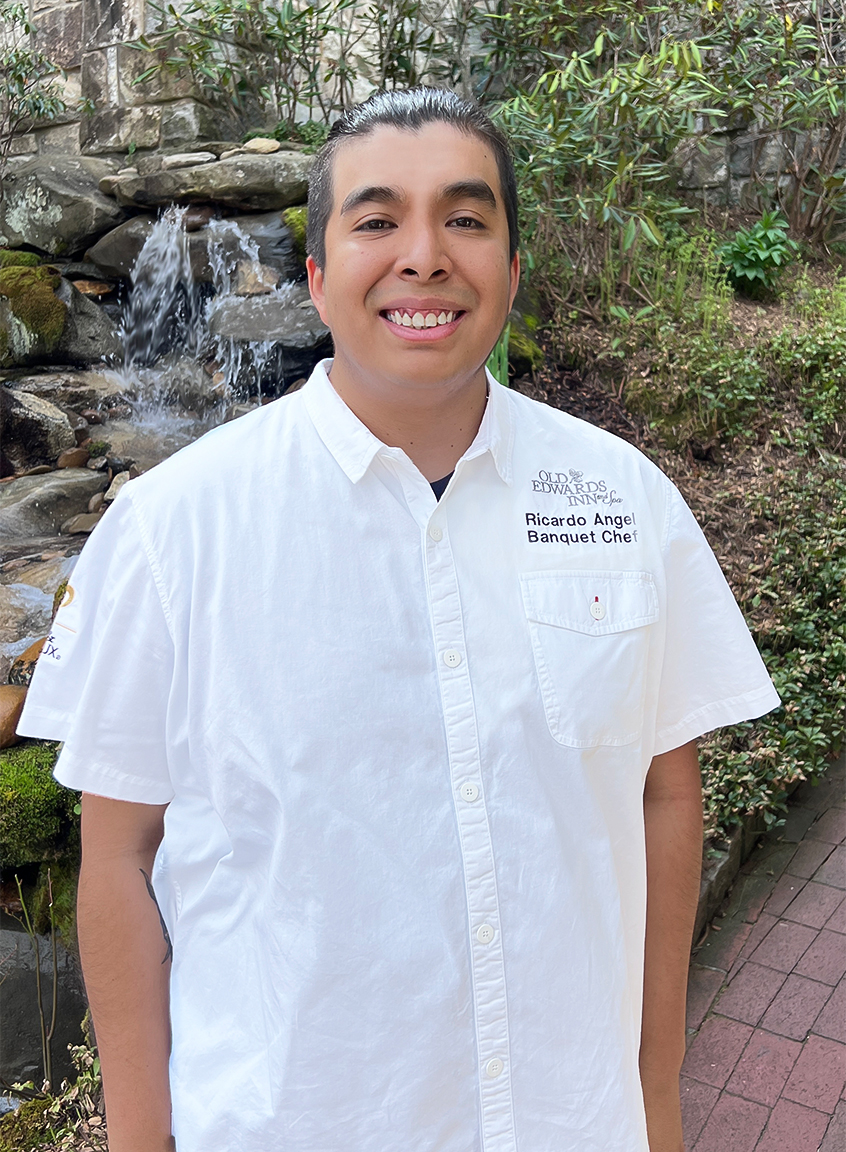 a man smiling in front of a waterfall