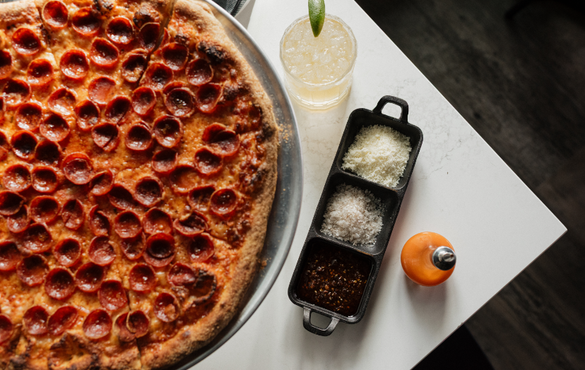 a pizza and a drink on a table