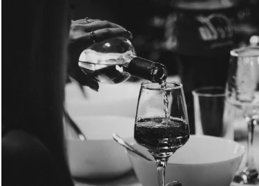 a person pouring wine into a glass