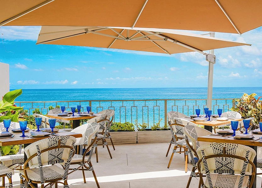 a table and chairs on a patio overlooking the ocean