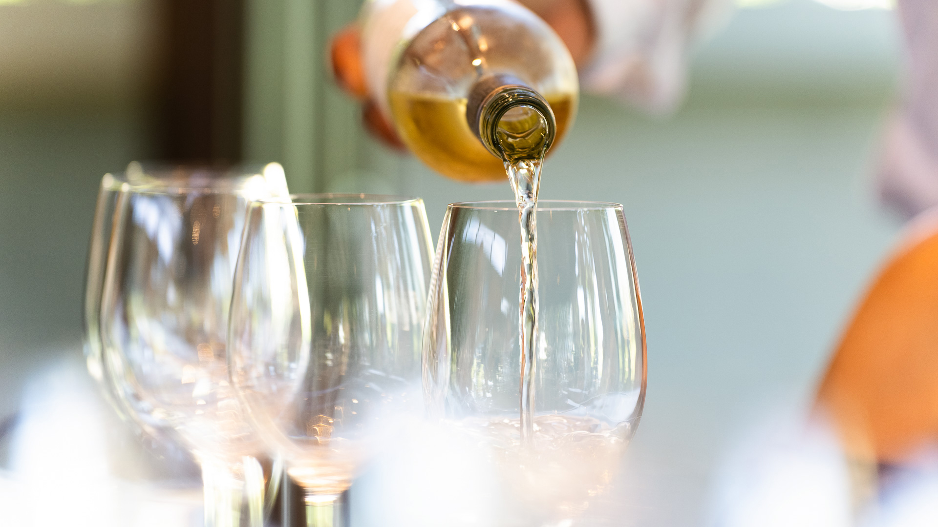 a person pouring wine into a glass