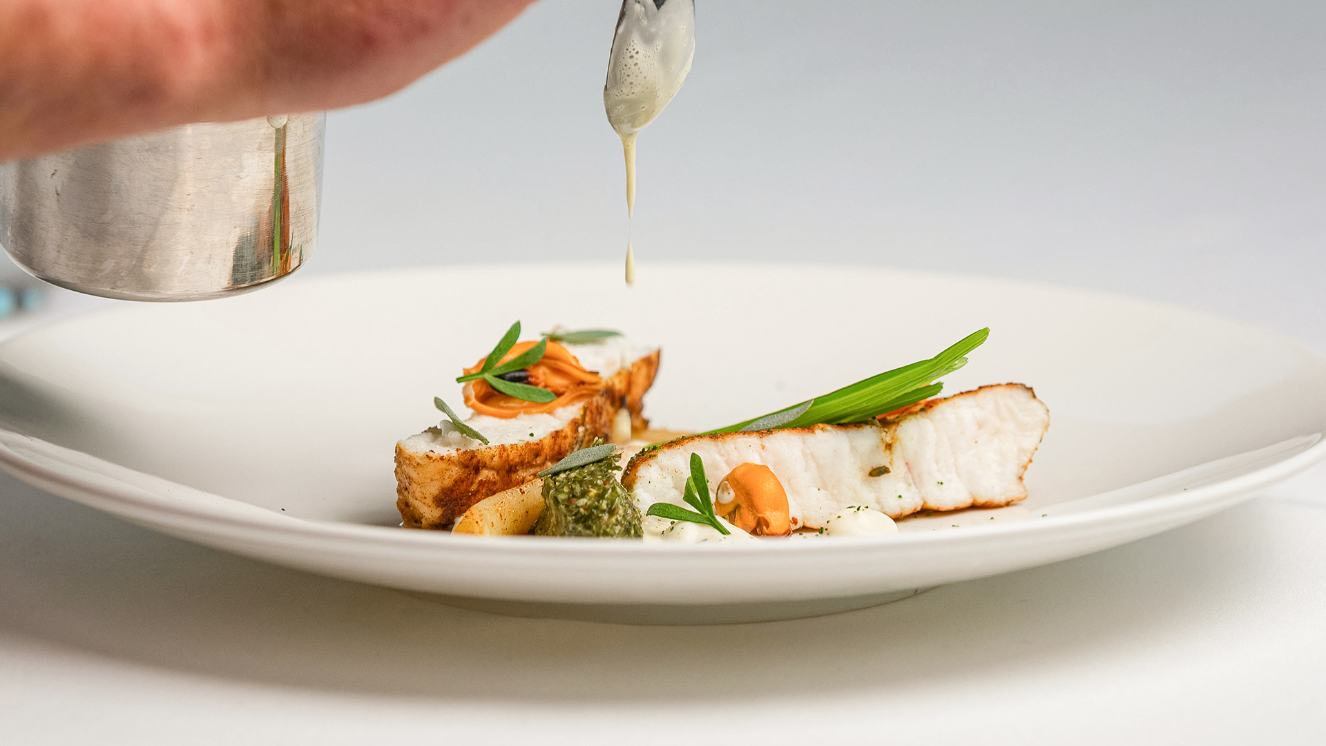 a plate of food with sauce being poured over