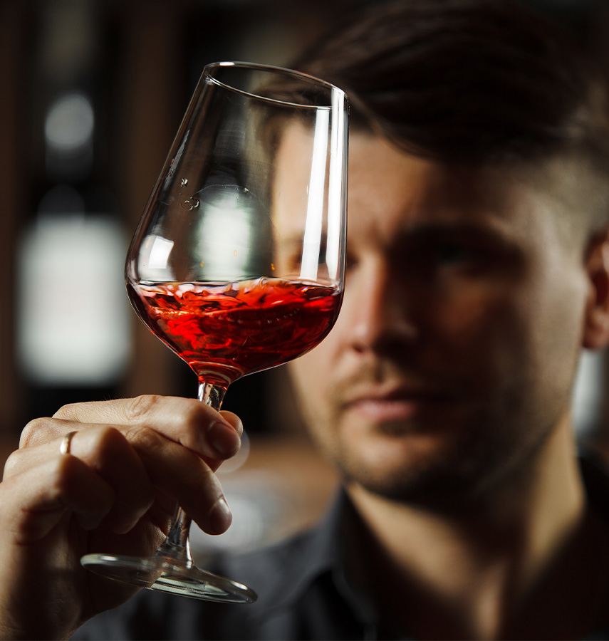a man holding a glass of red liquid
