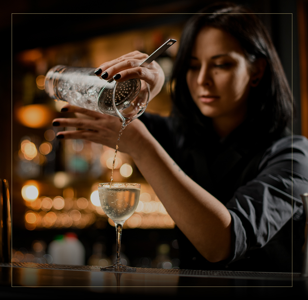 a woman pouring a drink into a glass