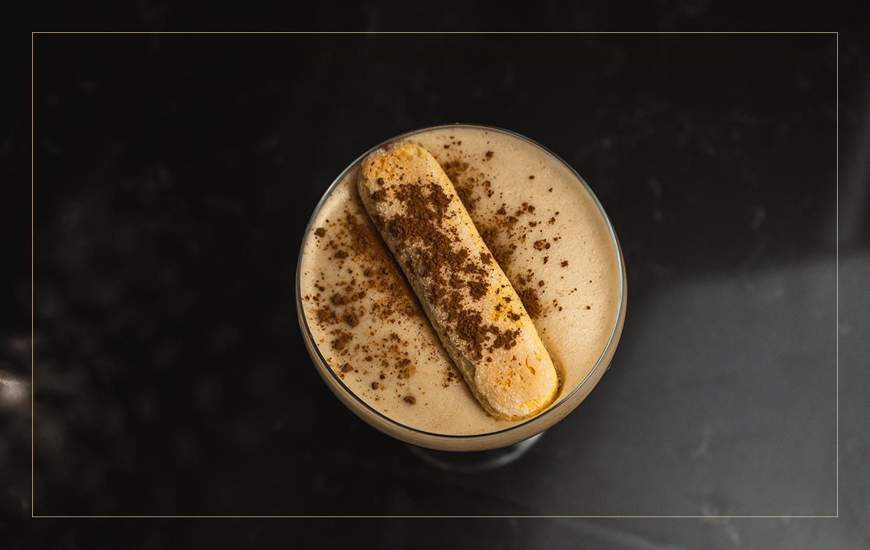 a glass of milkshake with a cookie on top
