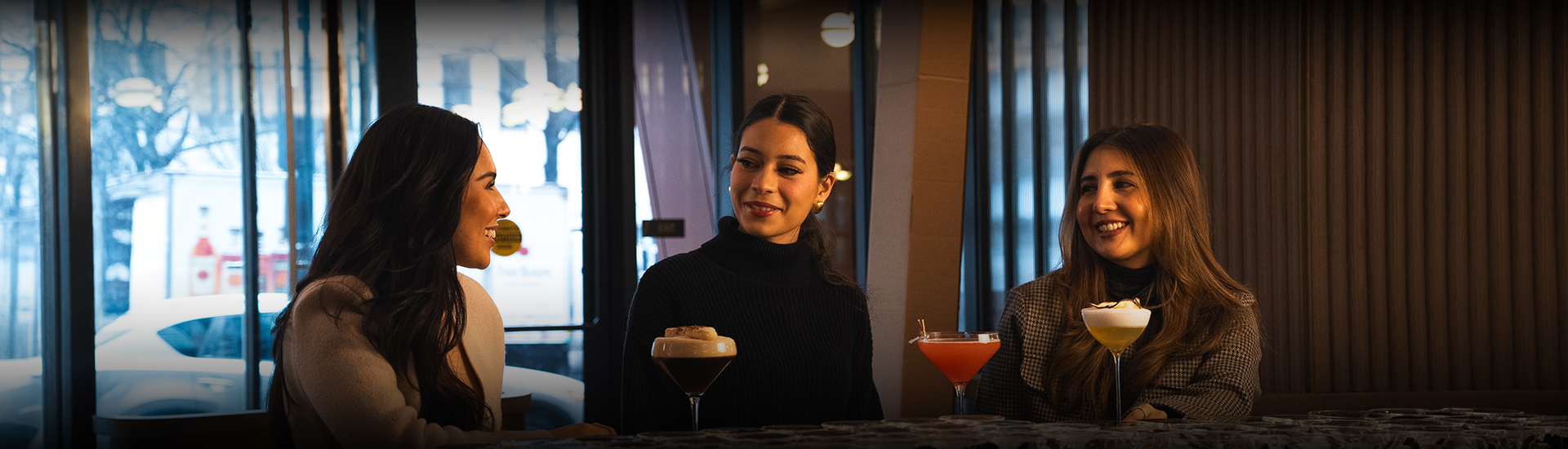 a woman smiling at a bar with drinks