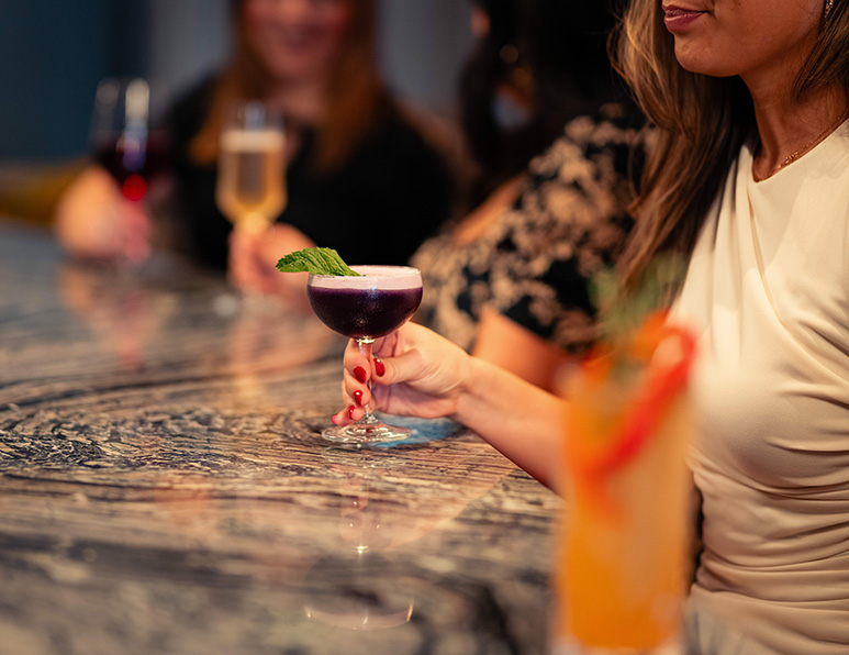 a woman holding a glass of drink