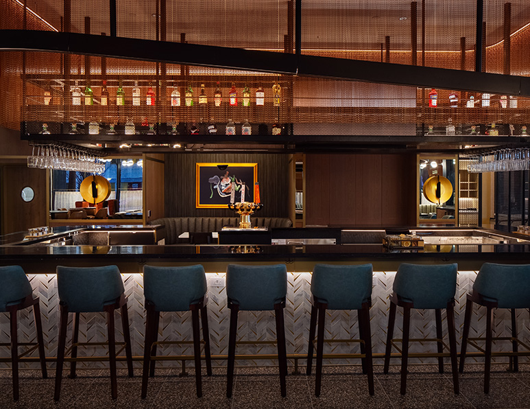 a bar with chairs and a bar