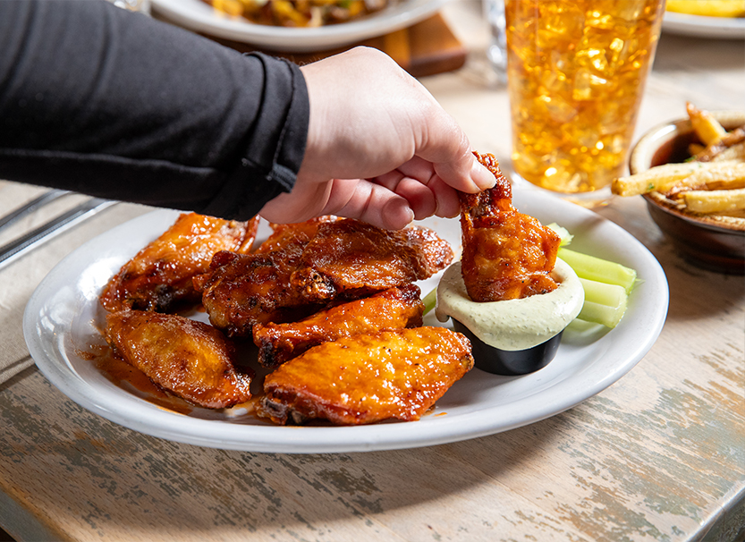a plate of chicken wings and dip