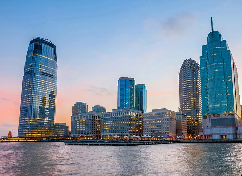 a city skyline with many tall buildings and a body of water
