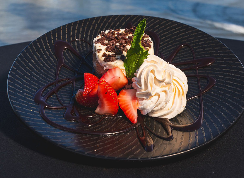 a plate of dessert with strawberries and whipped cream