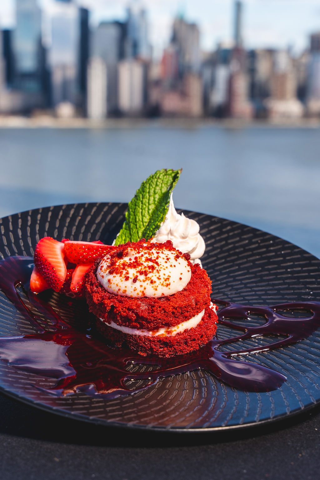 a plate of dessert with a city in the background