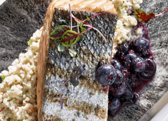 a piece of fish with berries on top of it