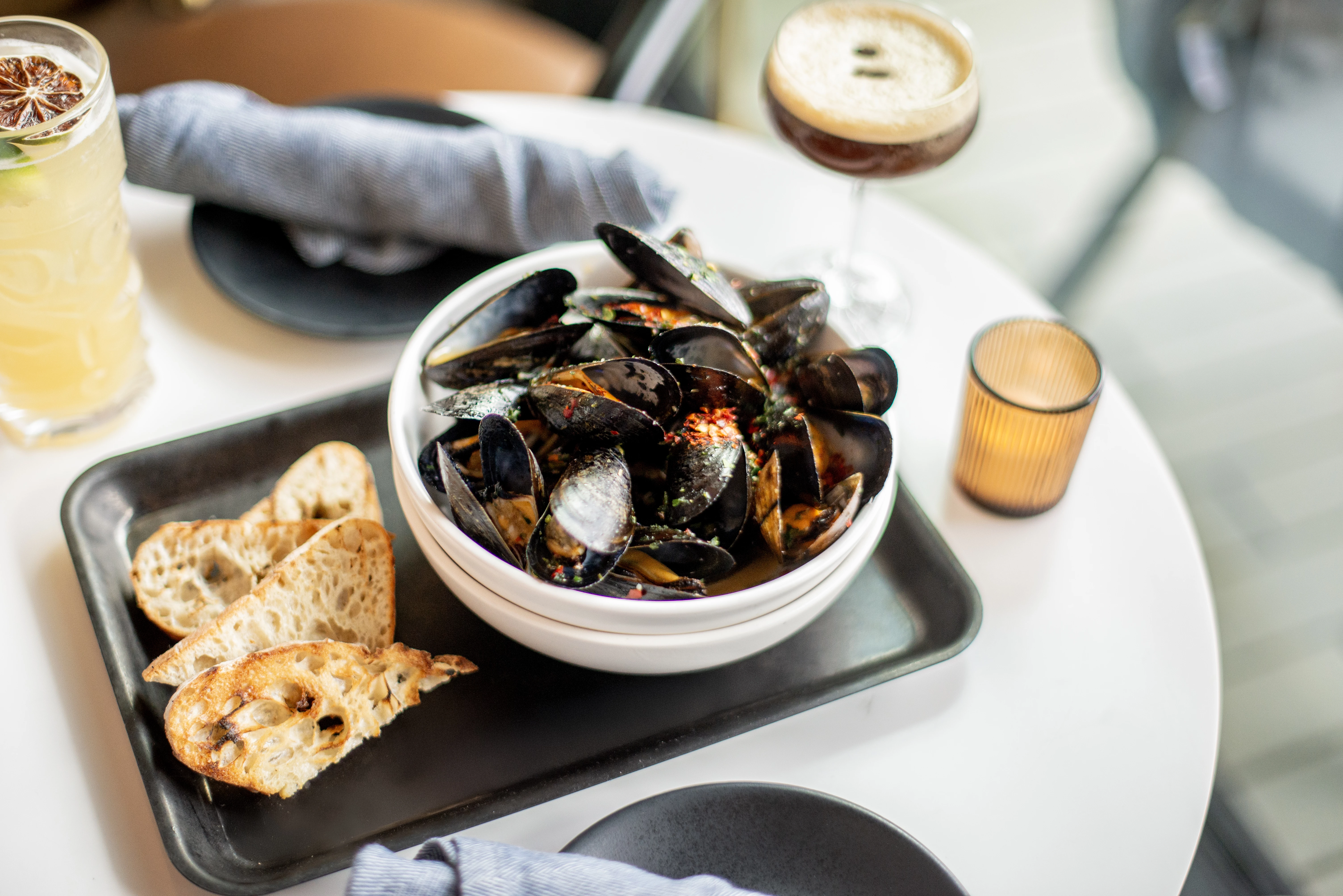 a bowl of mussels and a glass of wine