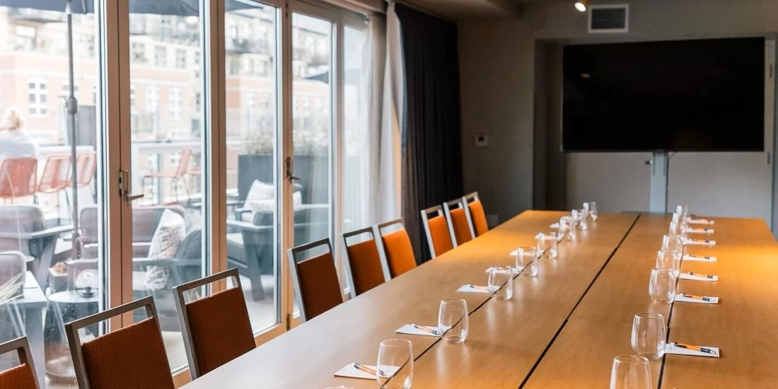 a long table with chairs and glasses on it
