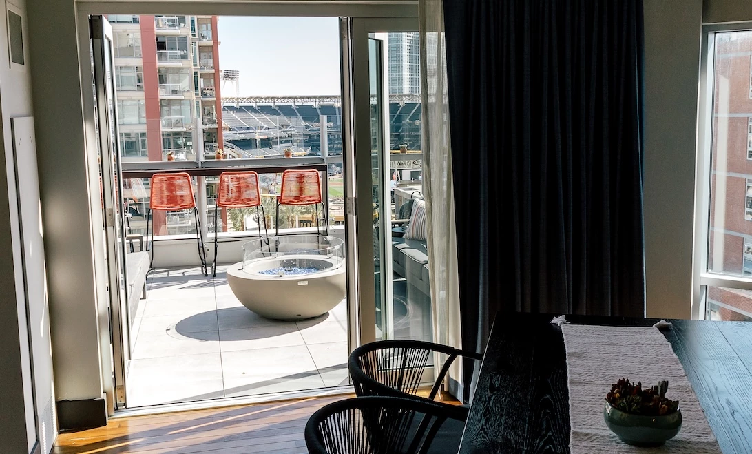 a room with a table and chairs and a pool outside