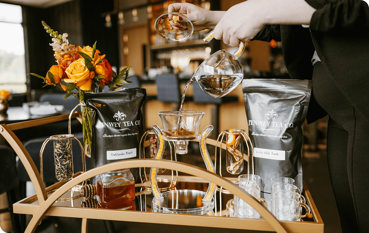 a person pouring liquid into a glass cup