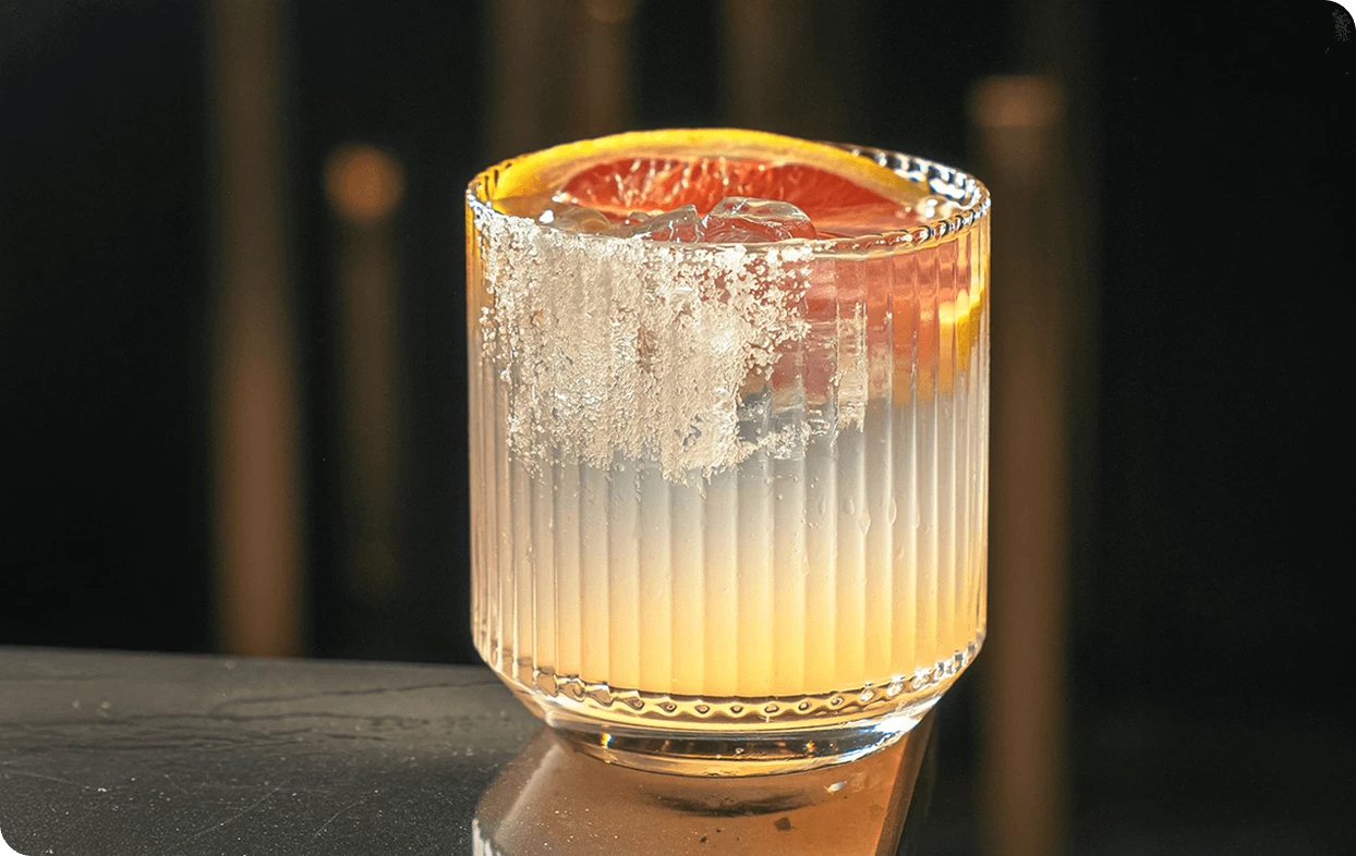 a glass with a drink and a slice of orange