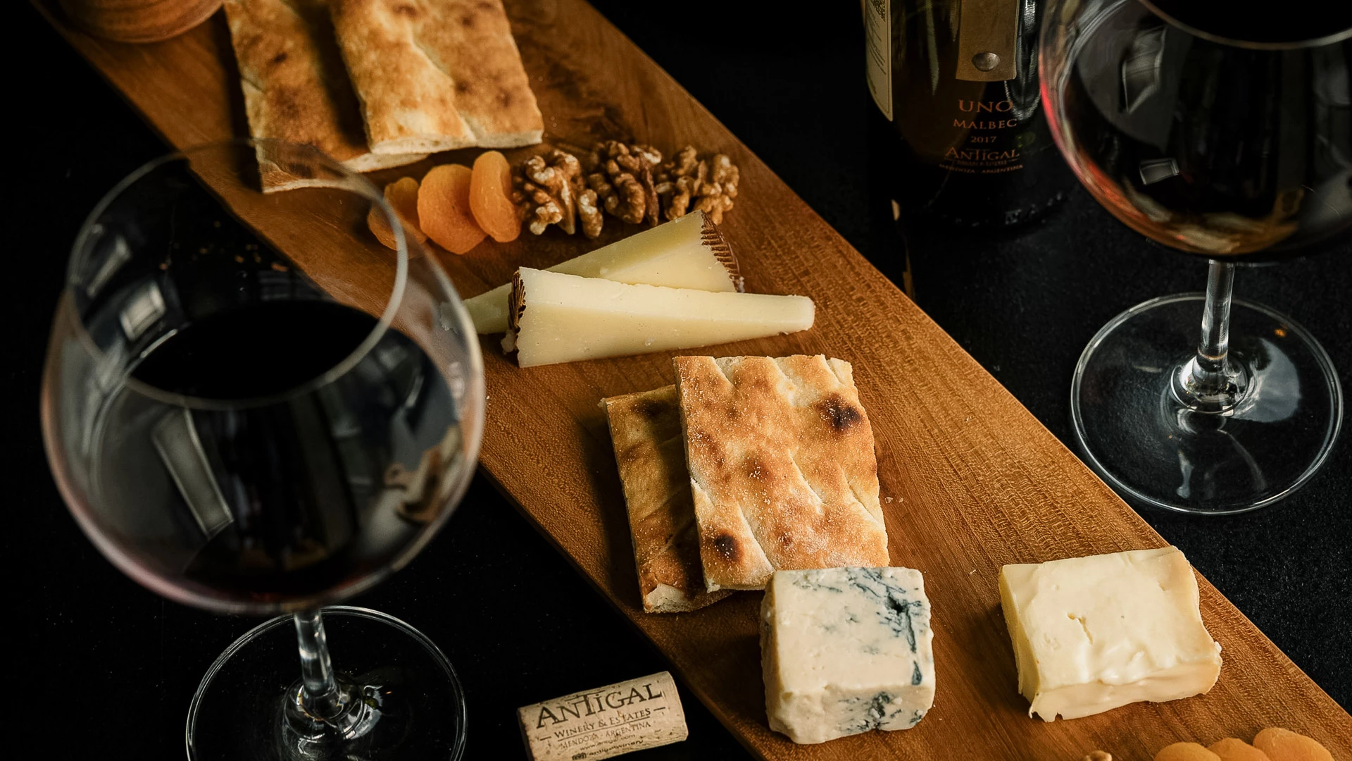 a cheese and nuts on a wooden board