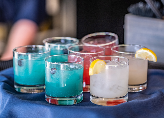 a group of glasses with different colored drinks